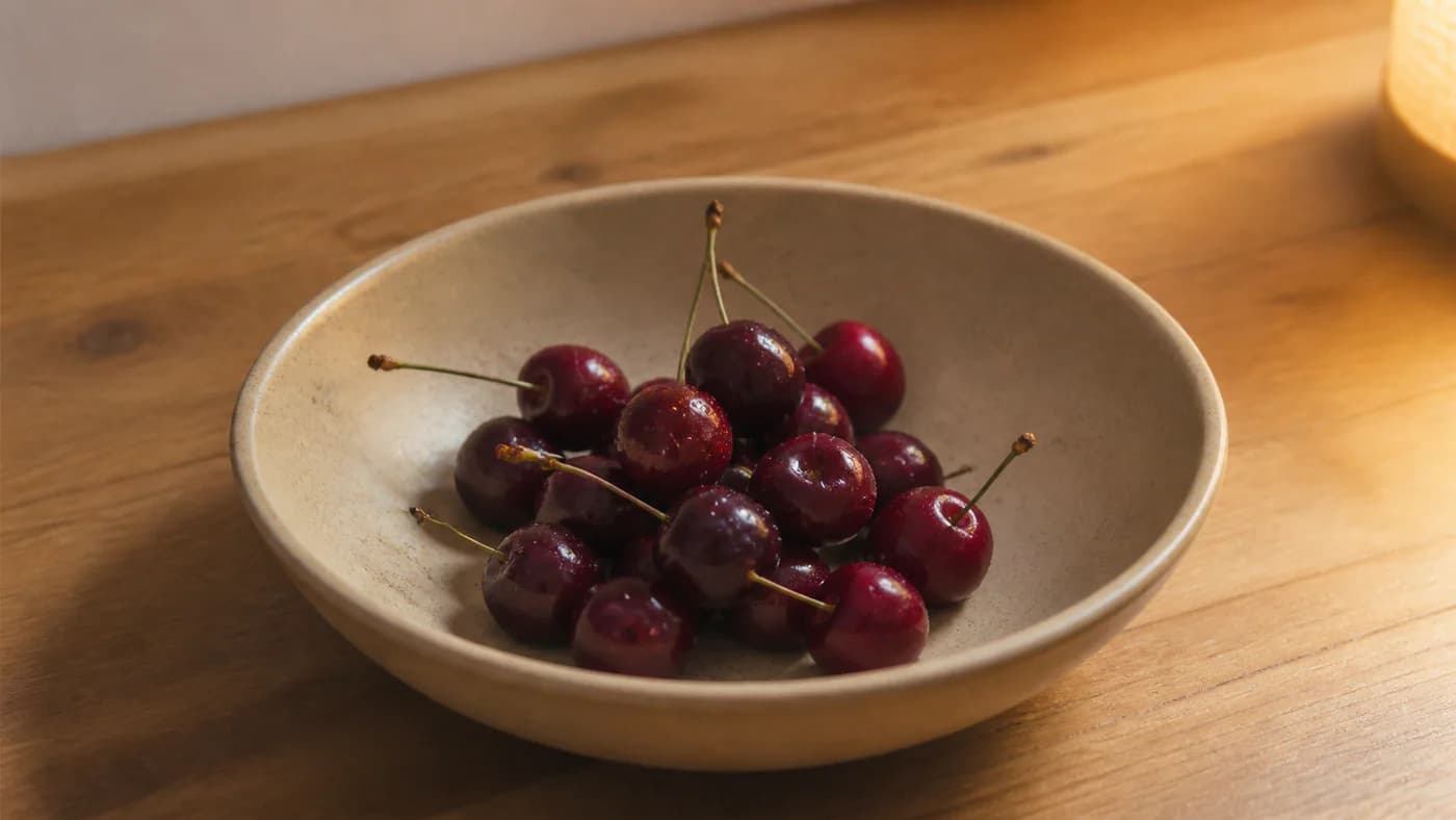 Small serving of tart cherries in a shallow ceramic bowl